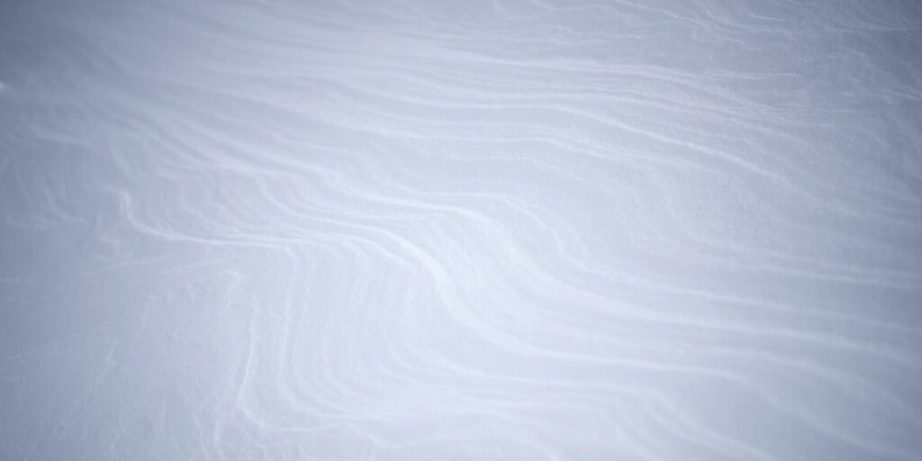 a snowboarder is going down a snowy hill