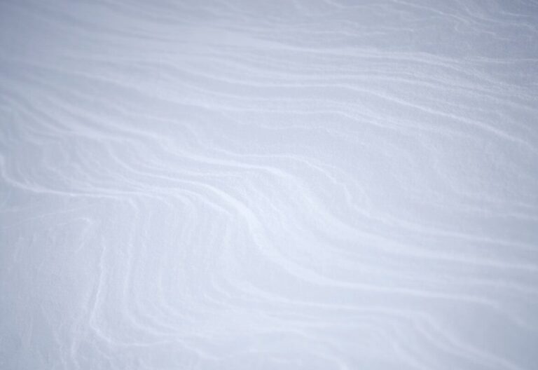 a snowboarder is going down a snowy hill