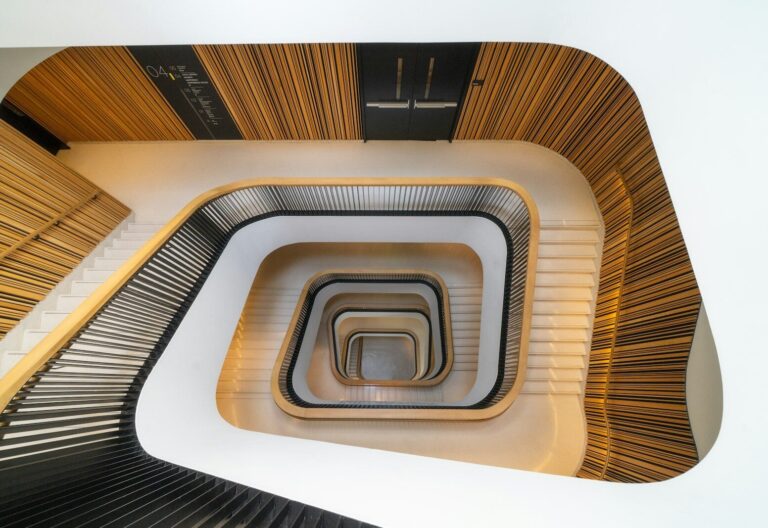 Modern spiral staircase with wooden accents and white walls
