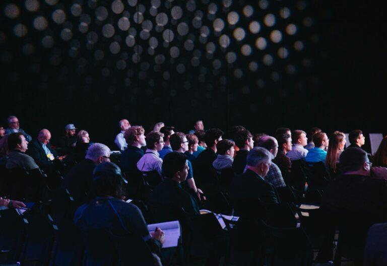 crowd of people sitting on chairs inside room
